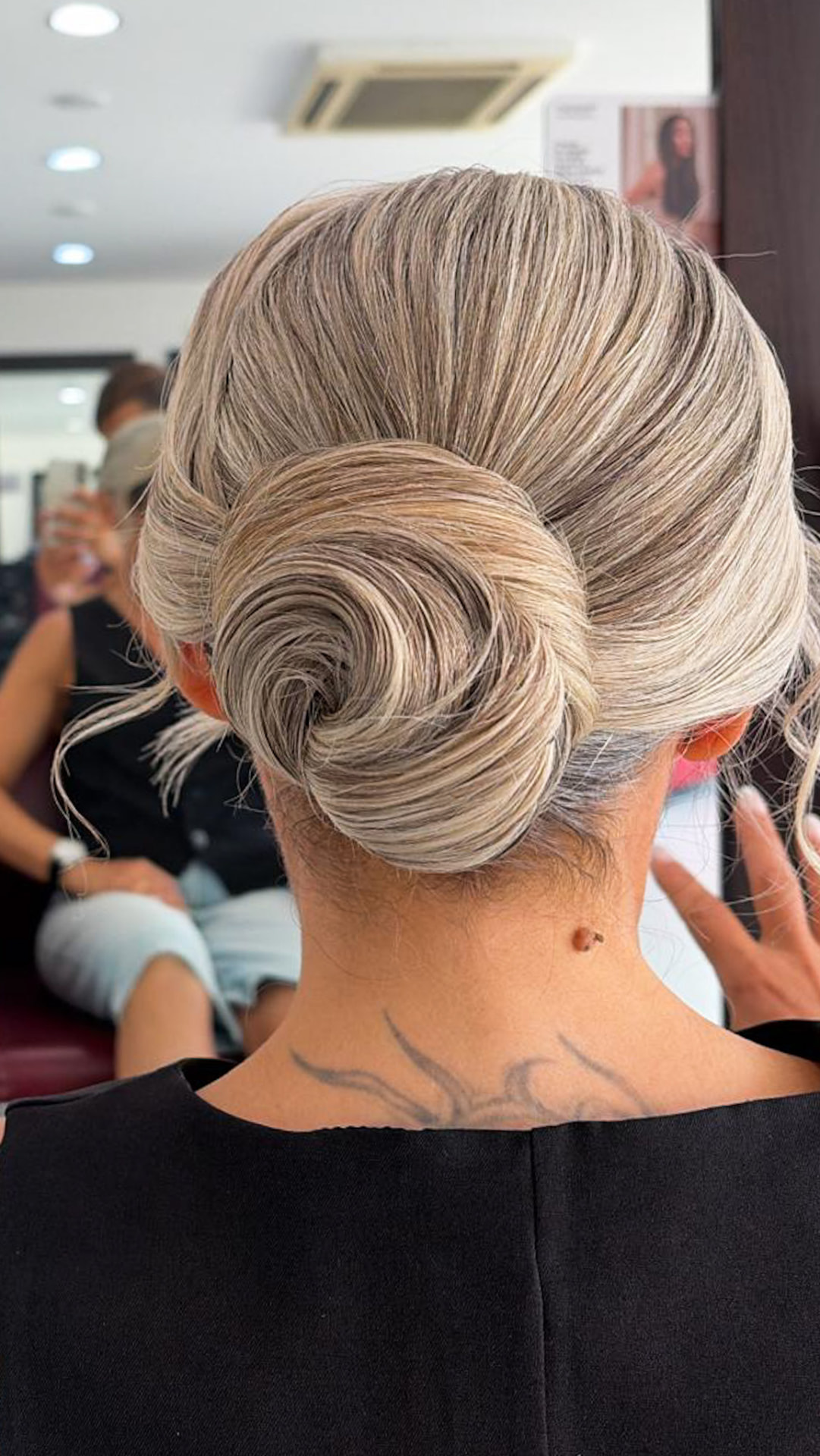 Chignon basso raffinato su capelli biondo cenere